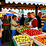 **A bustling Estonian market scene near Tallinn.** Focus on the frustration of a traveler searching for an ATM, unable to use their card at a stall selling local crafts and produce. Capture the vibrant colors of the market contrasting with the traveler's stressed expression. Consider including elements that evoke a sense of Estonian culture (traditional patterns, local food).